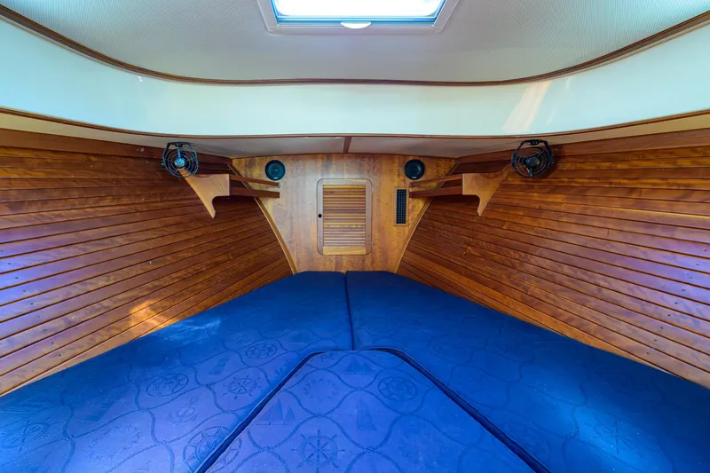 Cara Mia Yacht Photos Pics 2010 Hinckley Picnic Boat 37 MKIII cabin interior with wooden paneling and blue cushions.