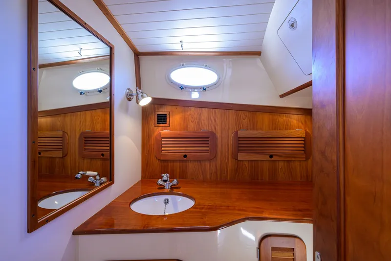 Cara Mia Yacht Photos Pics Elegant wooden interior of 2010 Hinckley Picnic Boat 37 MKIII bathroom with sink and mirror.