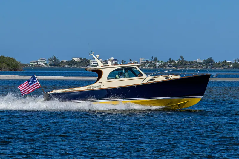 Cara Mia Yacht Photos Pics Hinckley Picnic Boat 37 MKIII cruising on water, 2010 model, with American flag.