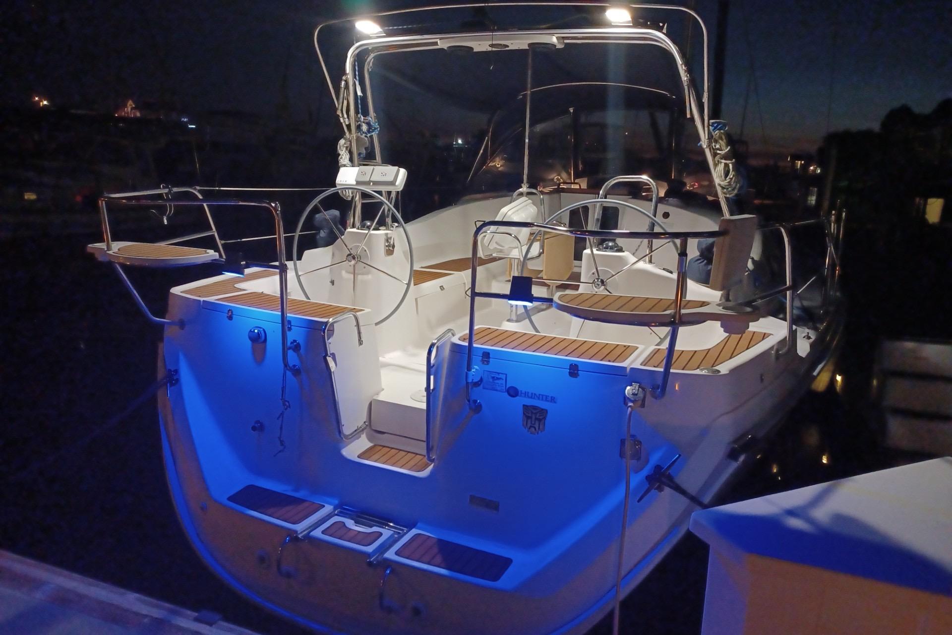 2011 Hunter 45 Deck Salon sailboat illuminated at night, docked with blue accent lighting.