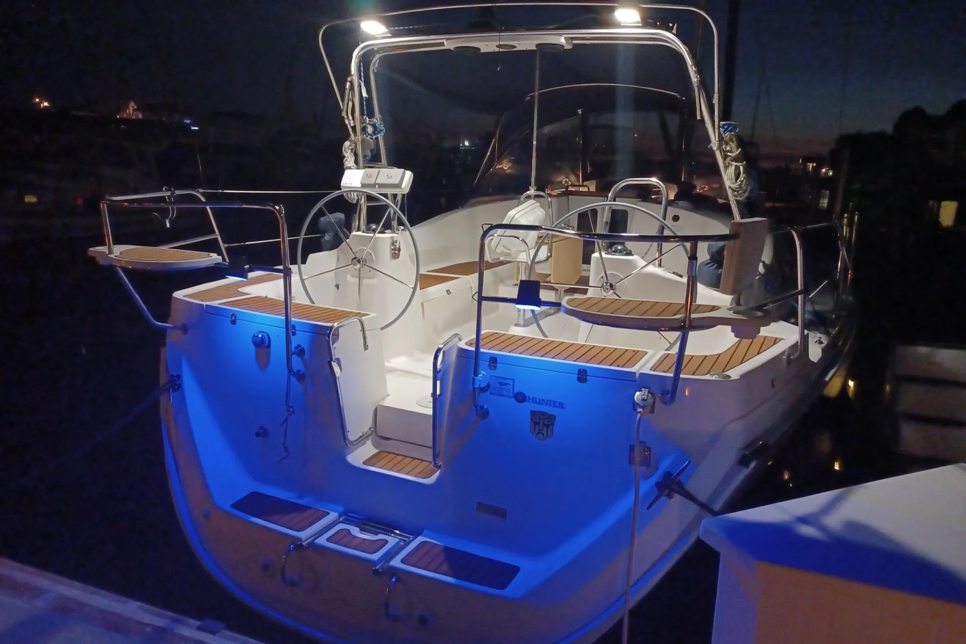 2011 Hunter 45 Deck Salon sailboat illuminated at night, docked with blue accent lighting.
