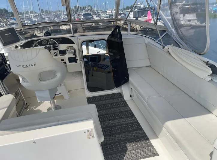  Yacht Photos Pics 2005 Meridian 490 Pilothouse interior with helm, seating, and marina view.