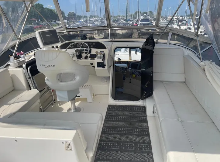  Yacht Photos Pics 2005 Meridian 490 Pilothouse interior with helm, seating, and marina view.