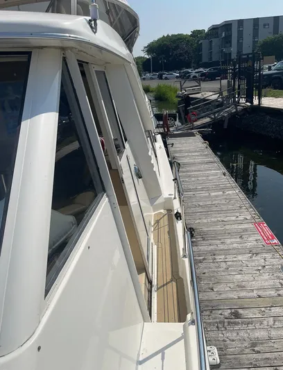  Yacht Photos Pics 2005 Meridian 490 Pilothouse yacht docked beside a wooden pier on a sunny day.