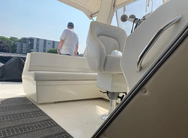  Yacht Photos Pics 2005 Meridian 490 Pilothouse interior with seating and steering area, person standing outside.