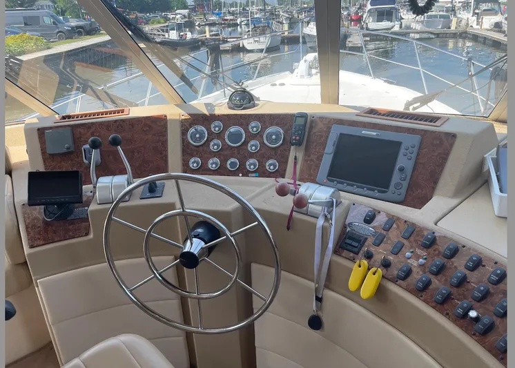  Yacht Photos Pics Pilothouse of 2005 Meridian 490 yacht with steering wheel, gauges, and navigation equipment.
