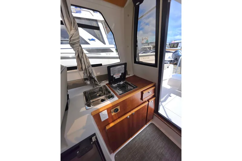  Yacht Photos Pics 2020 Cutwater C-24 boat interior with compact kitchen, sink, and stove.