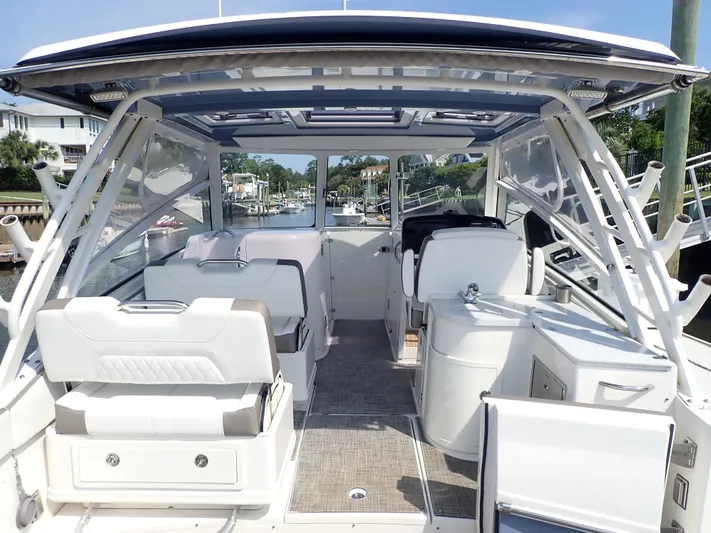 2022 World Cat 325 Dc Yacht Photos Pics 2022 World Cat 325 DC boat interior with seating and helm, docked in a marina.