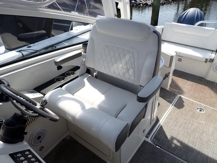 2022 World Cat 325 Dc Yacht Photos Pics Captain's chair on 2022 World Cat 325 DC boat, featuring luxurious white upholstery and modern design.