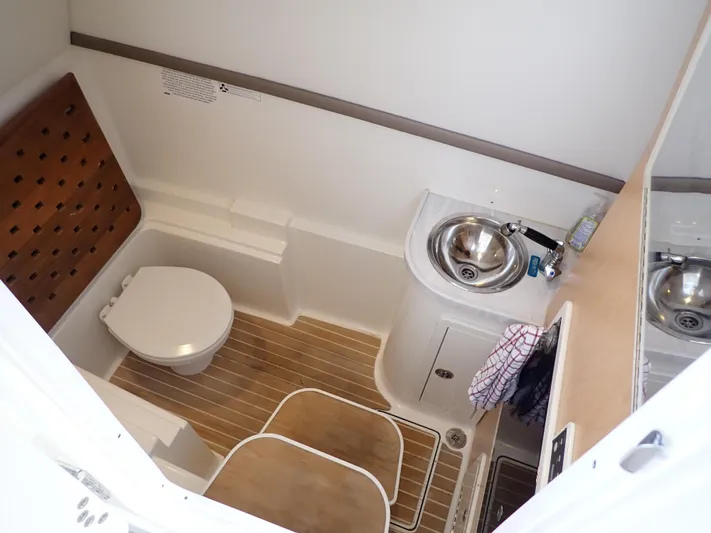2022 World Cat 325 Dc Yacht Photos Pics 2022 World Cat 325 DC boat bathroom with toilet, sink, and wooden flooring.
