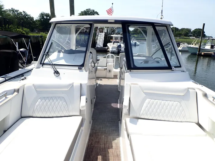 2022 World Cat 325 Dc Yacht Photos Pics 2022 World Cat 325 DC boat interior with white seating, docked in a marina.