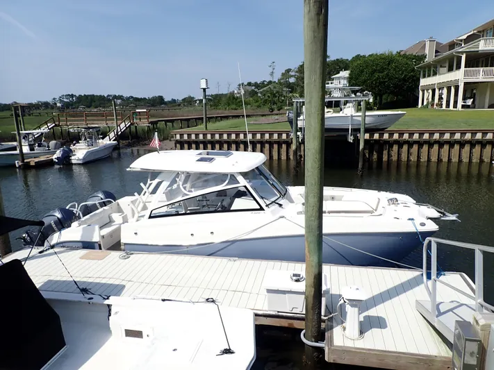 2022 World Cat 325 Dc Yacht Photos Pics 2022 World Cat 325 DC boat docked at a marina with waterfront homes.