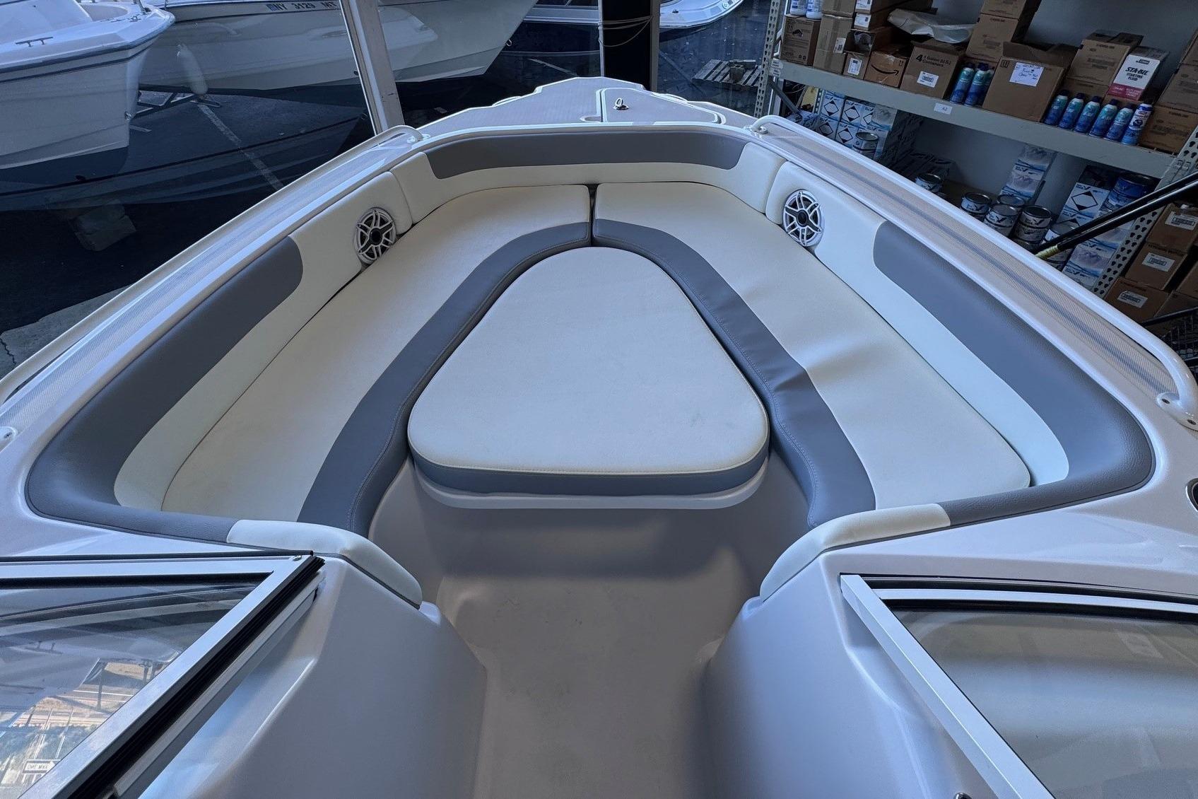 Interior of 2023 Release 230 DC boat with cushioned seating and speakers.