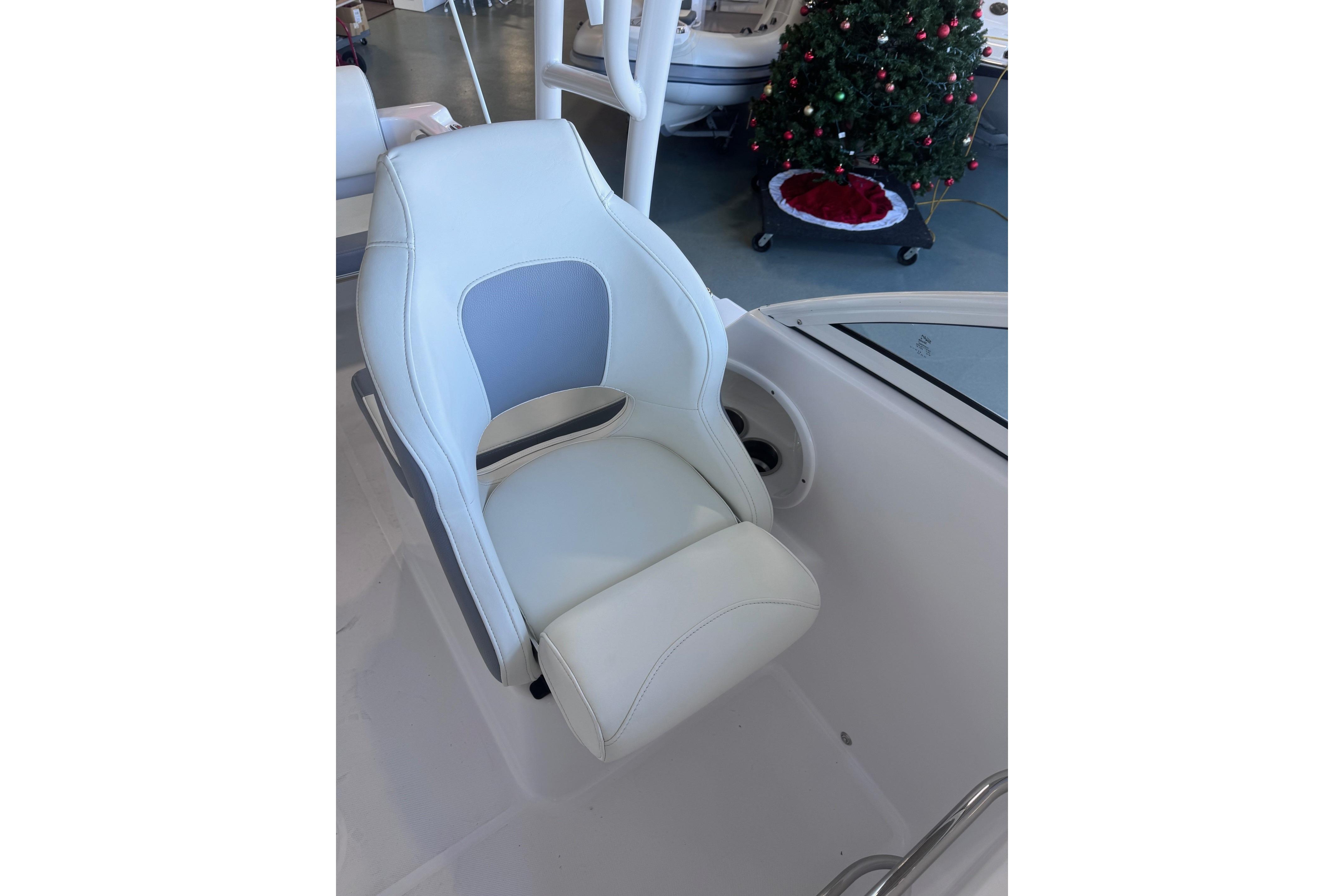 2023 Release 230 DC boat seat with white and gray upholstery, Christmas tree in background.