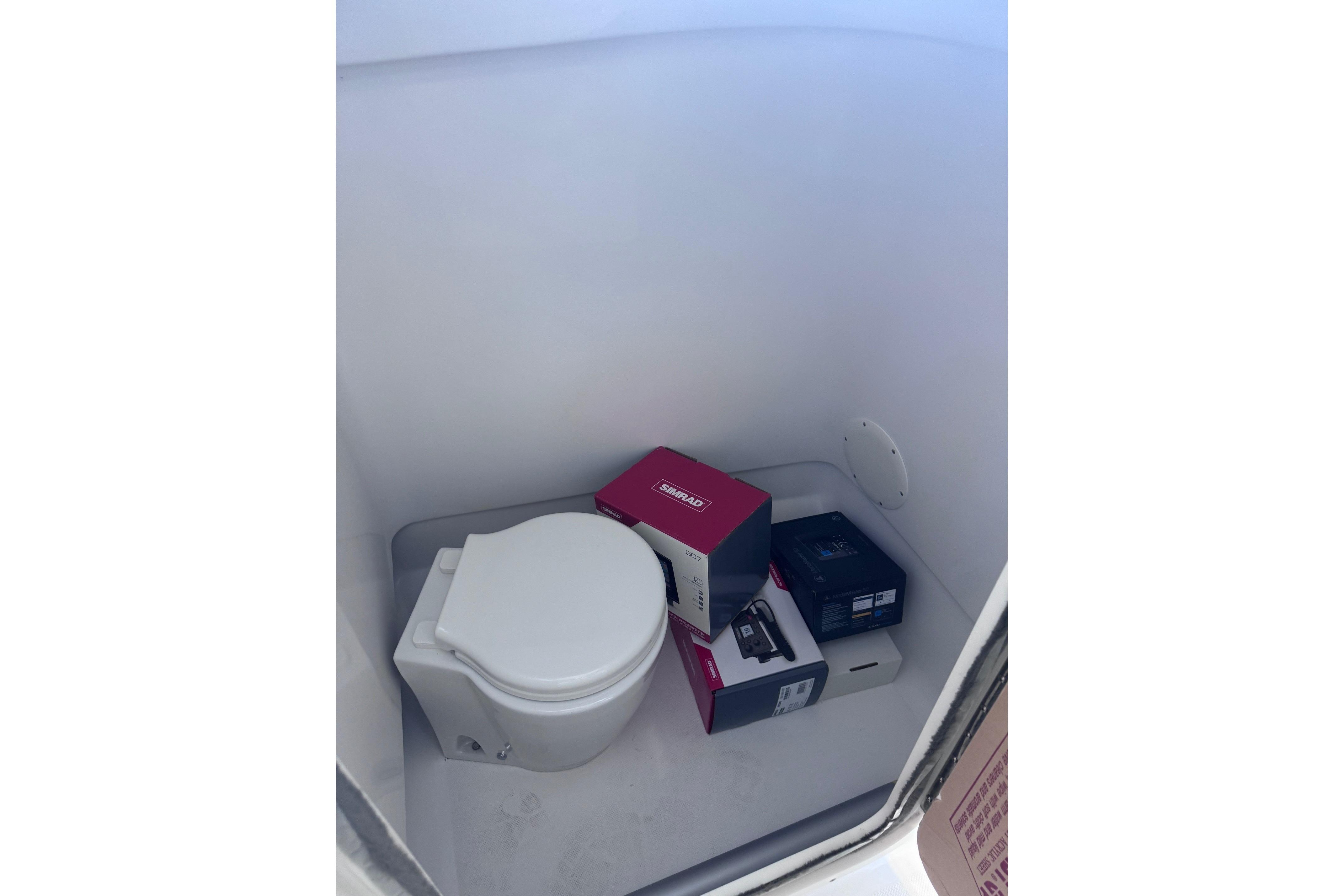 Boat interior with a toilet and electronic equipment boxes, Release 230 DC, 2023 model.