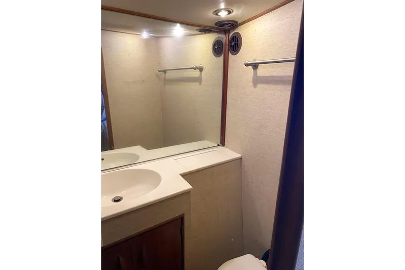 Rebel Child Yacht Photos Pics Bathroom interior of 1988 Buddy Davis 47 Custom Carolina yacht, featuring sink and mirror.