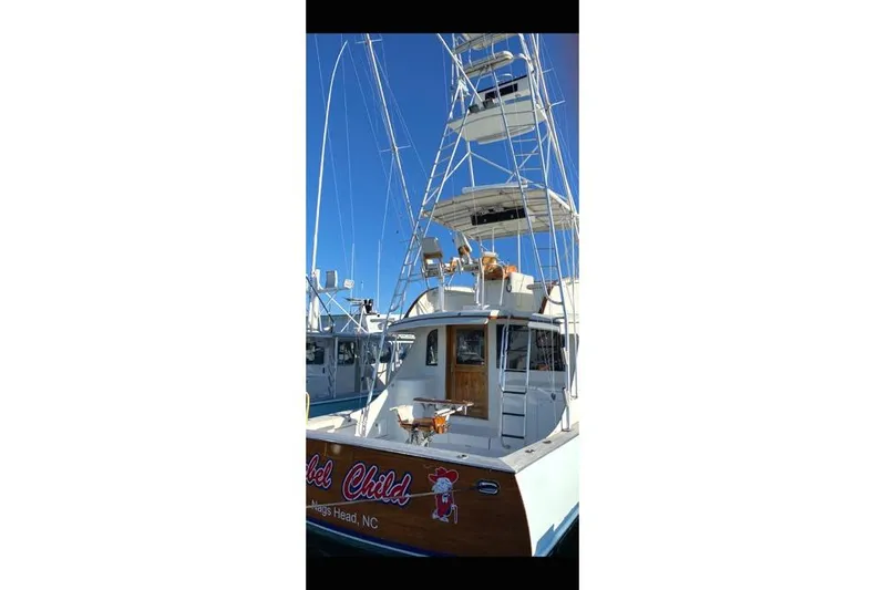 Rebel Child Yacht Photos Pics 1988 Buddy Davis 47 Custom Carolina boat with tall tower, docked under clear blue sky.