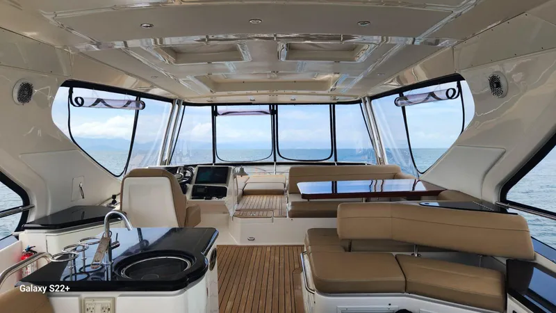 Zen Yacht Photos Pics Luxurious interior of 2015 Sea Ray L650 Fly yacht with panoramic windows and elegant seating.