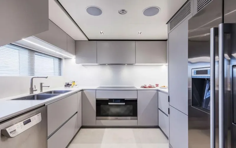  Yacht Photos Pics Modern kitchen interior on 2024 Custom Line Navetta 33 yacht, featuring sleek cabinetry and stainless steel appliances.