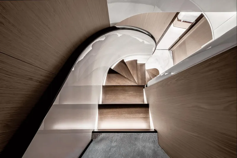  Yacht Photos Pics Luxurious wooden staircase inside 2025 Azimut Grande 27M yacht, featuring modern design and ambient lighting.