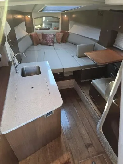  Yacht Photos Pics Interior of 2013 Sea Ray 310 Sundancer with kitchenette, seating, and wood flooring.
