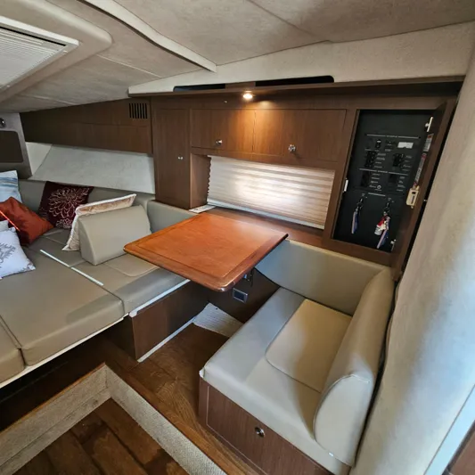  Yacht Photos Pics Interior of 2013 Sea Ray 310 Sundancer with cozy seating and wooden table.
