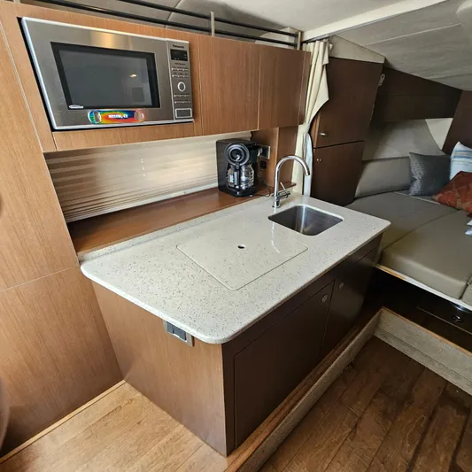 Yacht Photos Pics 2013 Sea Ray 310 Sundancer interior with kitchenette, featuring microwave and sink.