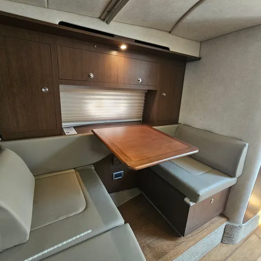  Yacht Photos Pics Interior of 2013 Sea Ray 310 Sundancer with cozy seating and wooden table.
