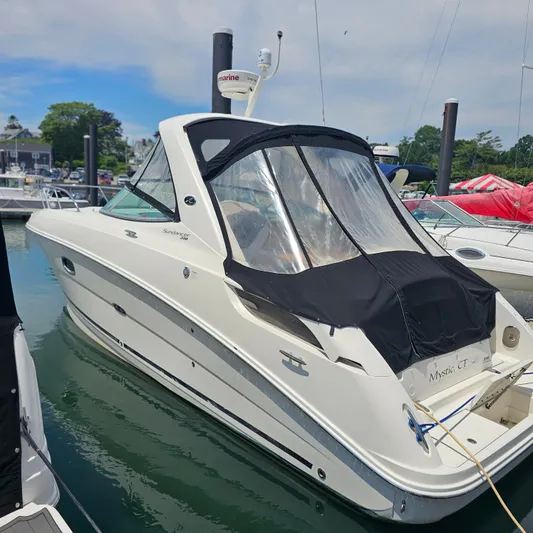  Yacht Photos Pics 2013 Sea Ray 310 Sundancer boat docked in a marina, featuring sleek design and black canopy.