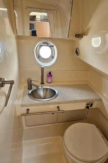  Yacht Photos Pics Bathroom interior of 2013 Sea Ray 310 Sundancer with sink, toilet, and porthole window.