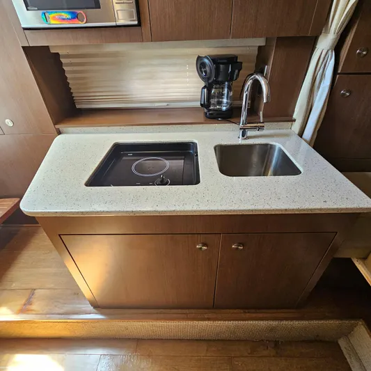  Yacht Photos Pics Compact kitchen area in 2013 Sea Ray 310 Sundancer yacht with sink and stove.