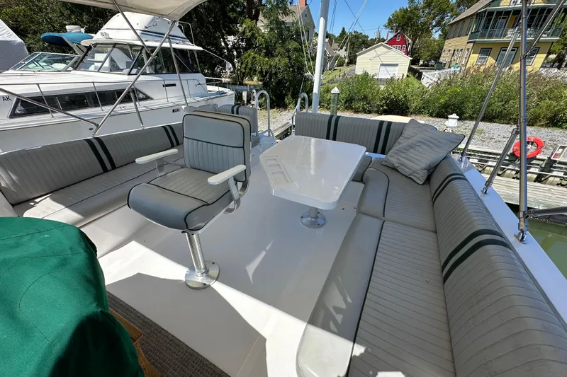  Yacht Photos Pics Aft deck of 2000 Mainship 43 Trawler with seating and table, docked near houses.