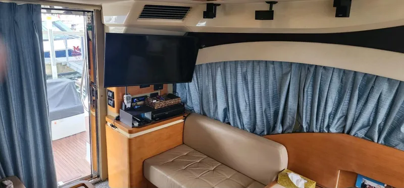 River Rat Yacht Photos Pics Interior of 2013 Azimut 45 Flybridge yacht with sofa, TV, and blue curtains.