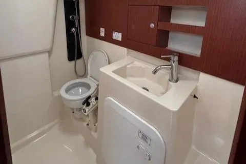  Yacht Photos Pics 2016 Hanse 315 yacht bathroom with toilet, sink, and wooden cabinetry.