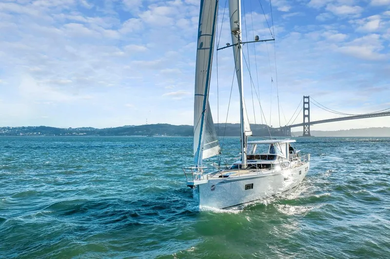 No Retreat Yacht Photos Pics Sailing yacht Hylas H57 (2020) cruising near a bridge on a sunny day.