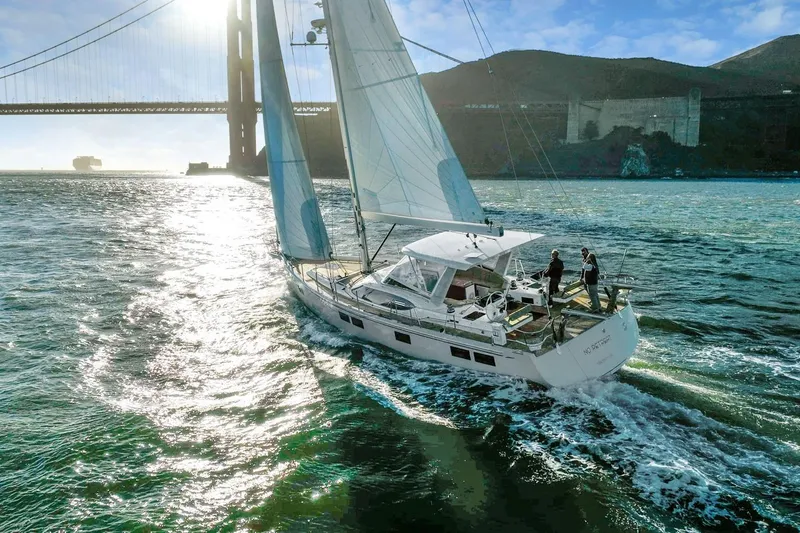 No Retreat Yacht Photos Pics Sailing yacht Hylas H57, 2020 model, cruising near a large bridge on a sunny day.