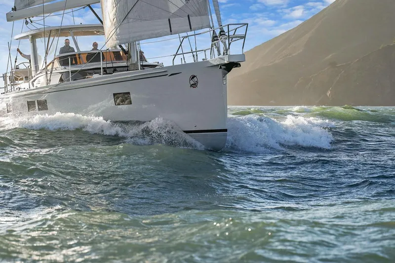 No Retreat Yacht Photos Pics Sailing yacht Hylas H57 (2020) navigating waves with mountainous backdrop.