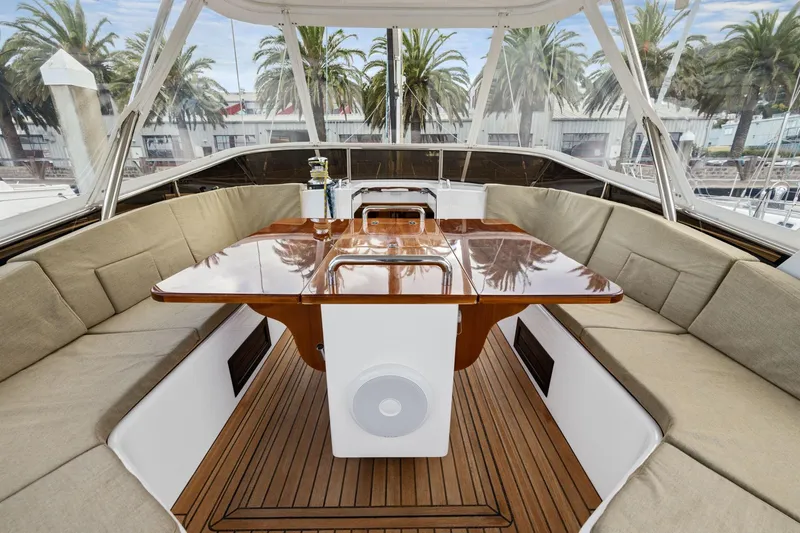 No Retreat Yacht Photos Pics Luxurious 2020 Hylas H57 yacht cockpit with elegant wood table and cushioned seating.