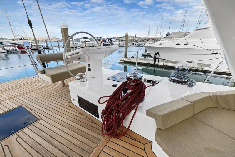 No Retreat Yacht Photos Pics Luxury Hylas H57 yacht deck with steering wheel, ropes, and marina view, 2020 model.