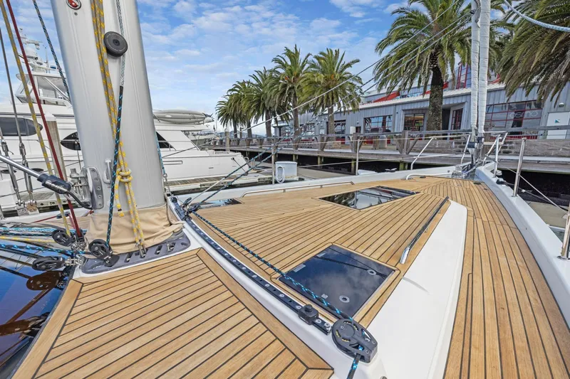 No Retreat Yacht Photos Pics Deck of 2020 Hylas H57 yacht with teak finish, docked near palm trees.