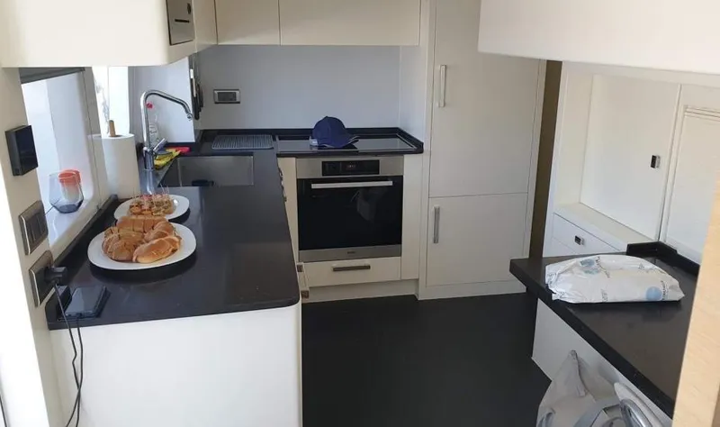  Yacht Photos Pics Modern kitchen in a 2013 Benetti Delfino 93 yacht with black countertops and white cabinets.