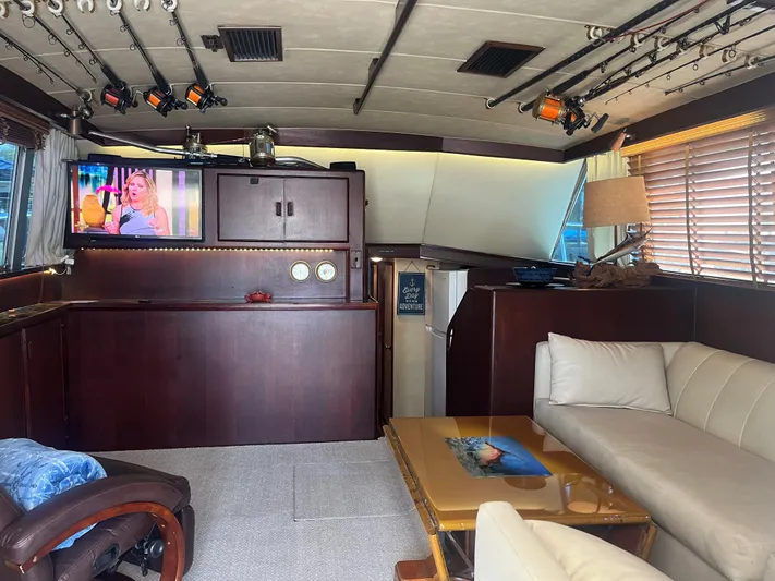 Laid Back Yacht Photos Pics Interior of a 1983 Bertram 46 Convertible yacht with cozy seating and fishing rods.