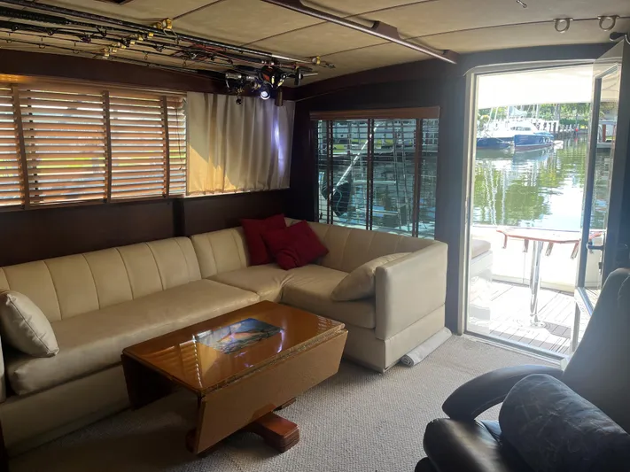 Laid Back Yacht Photos Pics Interior of 1983 Bertram 46 Convertible yacht with beige sofa and wooden table.