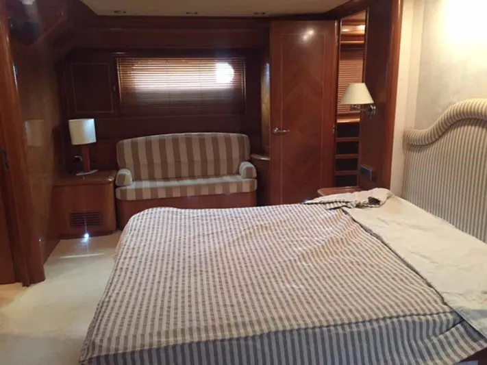  Yacht Photos Pics Luxurious bedroom interior in 2006 ABD 60 yacht with striped bedding and wooden accents.