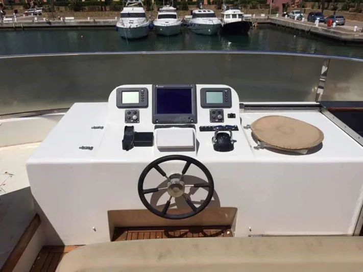  Yacht Photos Pics Control panel of a 2006 ABD 60 yacht with navigation equipment and steering wheel.