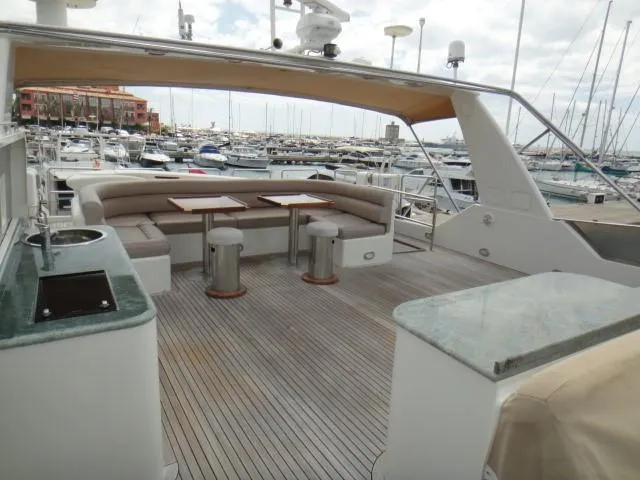  Yacht Photos Pics Luxury yacht deck with seating area, tables, and marina view; ABD 60, 2006 model.