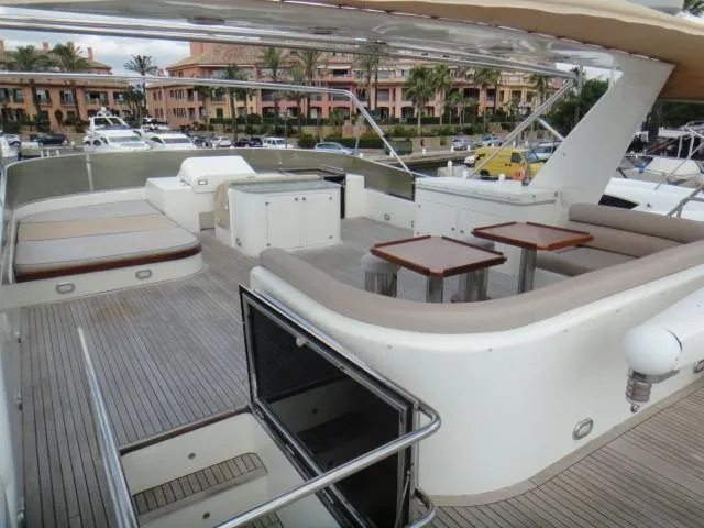  Yacht Photos Pics Luxurious 2006 ABD 60 yacht deck with seating and tables, docked at a marina.