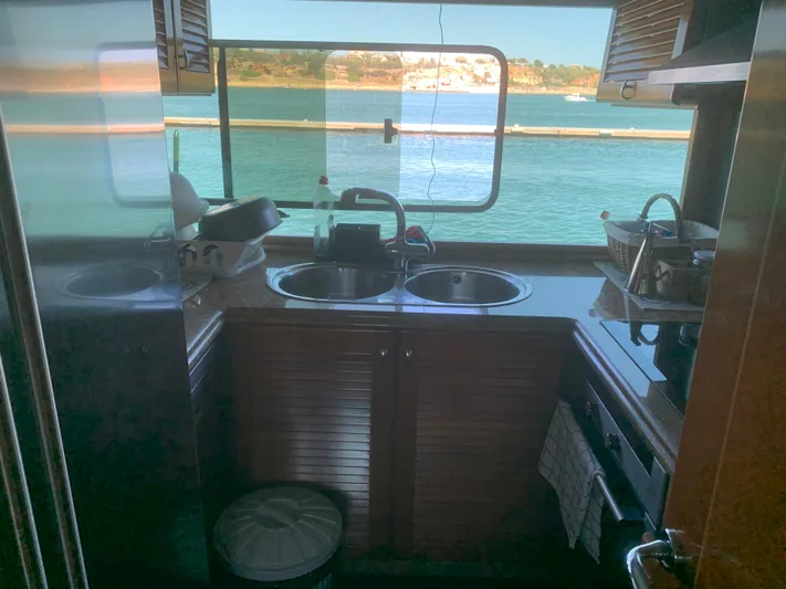  Yacht Photos Pics Compact kitchen on a 2006 ABD 60 yacht with ocean view through window.