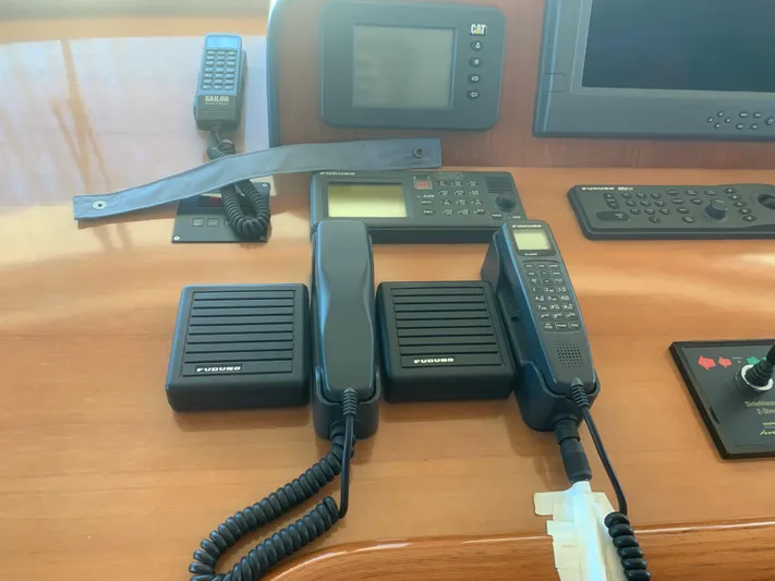  Yacht Photos Pics Boat communication equipment on a wooden console, featuring radios and control panels.