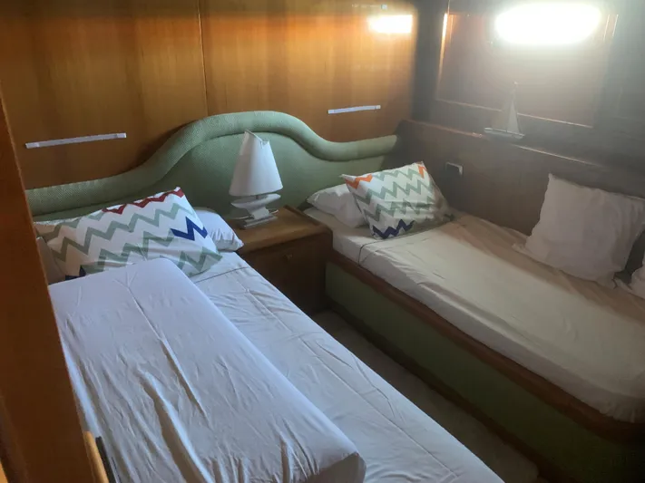  Yacht Photos Pics Twin beds in a cozy cabin with chevron pillows, wooden walls, and soft lighting.